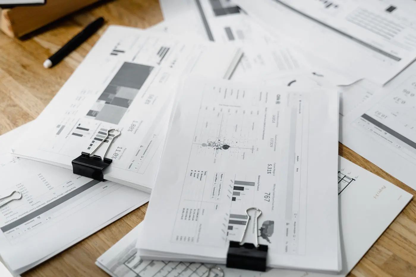 Rapoarte financiare cu grafice, prinse cu clipsuri, pe un birou